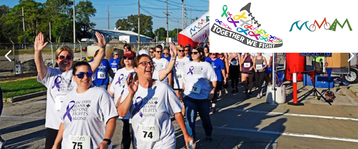 Participants from last year's Colors of Cancer Run waving at the camera. Together We Fight. M and M Multisport.